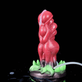 Red alien monster-style dildo with ridged body and green spiked demon claws