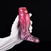 Fantasy cock sleeve extender in magenta-pink with textured ridges, worn with white gloves
