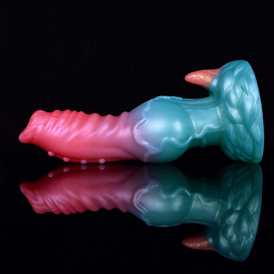 Adult novelty dildo side view, pink ridged shaft transitioning to teal head and legs