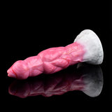 Pink translucent monster vibrator laid sideways with huge knot and white base