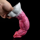Pink curved monster vibrator held in hand, translucent with raised textures