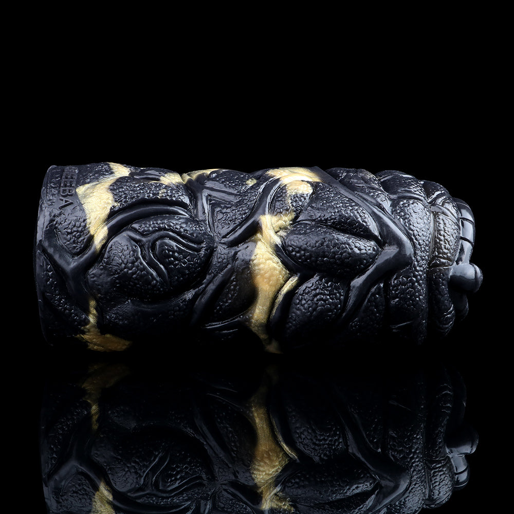 Side view of the black textured dual-hole stroker with gold stripes and raised details