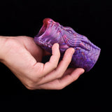 Purple dragon penis sleeve end with open rim, held in a hand