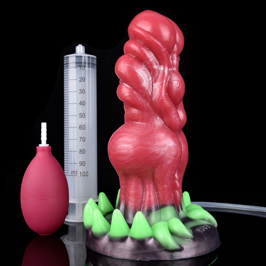 Adult novelty dildo with green claws, red alien body, plus measuring cylinder for scale