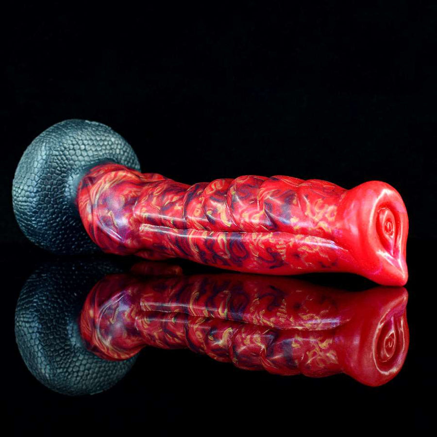Red marbled ribbed silicone novelty toy lying on textured base, side view
