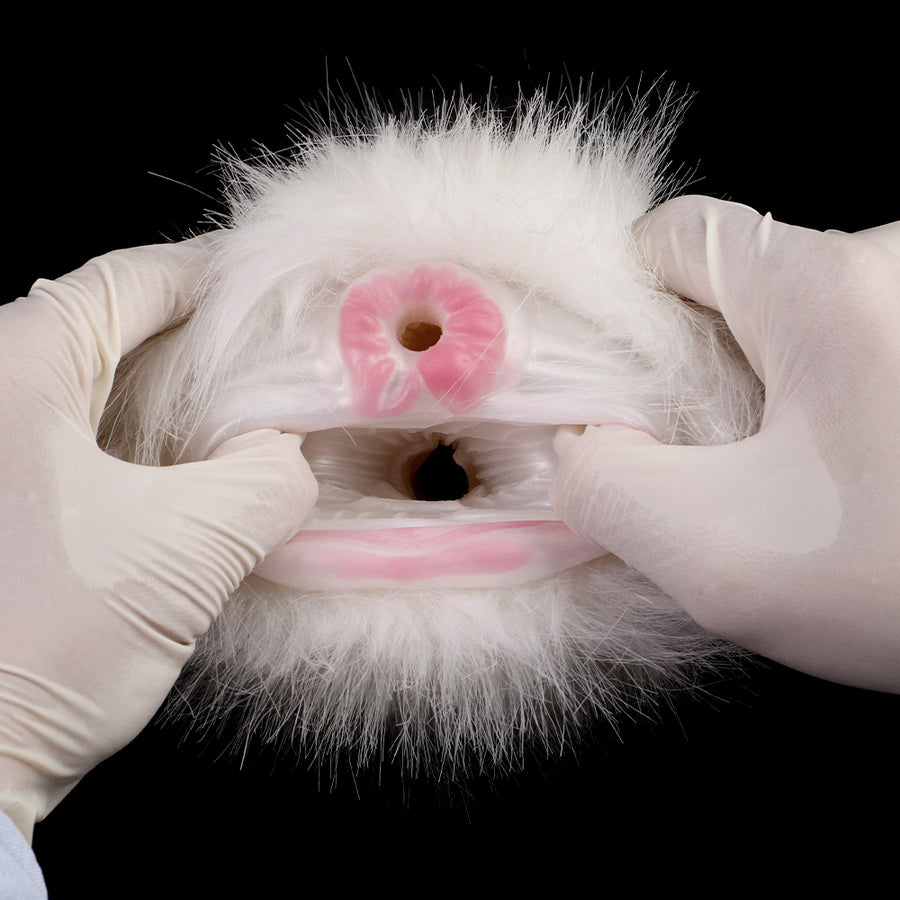White faux-fur dual-hole masturbator with pink openings, gloved hands holding it