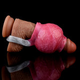 Pink enlargement sleeve on a dark-brown base with translucent strap ring, side view.