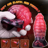 Pink dragon-scale anal plug with dark-purple underside; full-length product view