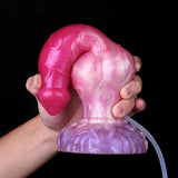 Pink dog-shaped dildo held in hand, focused on purple knot base and attached tube