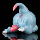 Light blue dragon toy curled on side with pink head crest, resting pose