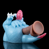 Light blue dragon toy with pink crest and raised base, brown inner sleeve visible