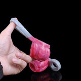 Rosa Drachen-Hülle mit grauem Ring in Seitenansicht, Hand hält das Teil