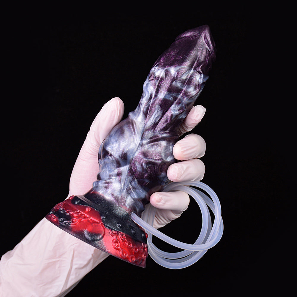 Gloved hand holding purple-and-red knot dildo with clear tube loop