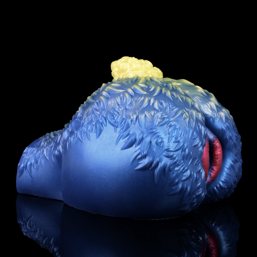 Blue sheep-shaped fantasy toy with yellow wool tuft and pink slit opening, rear close view