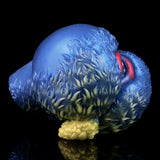 Blue sheep-shaped fantasy toy with yellow wool tuft and pink slit opening, side close-up