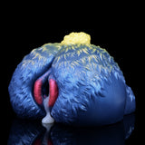 Blue sheep-shaped fantasy toy with yellow wool tuft and open pink slit, side view