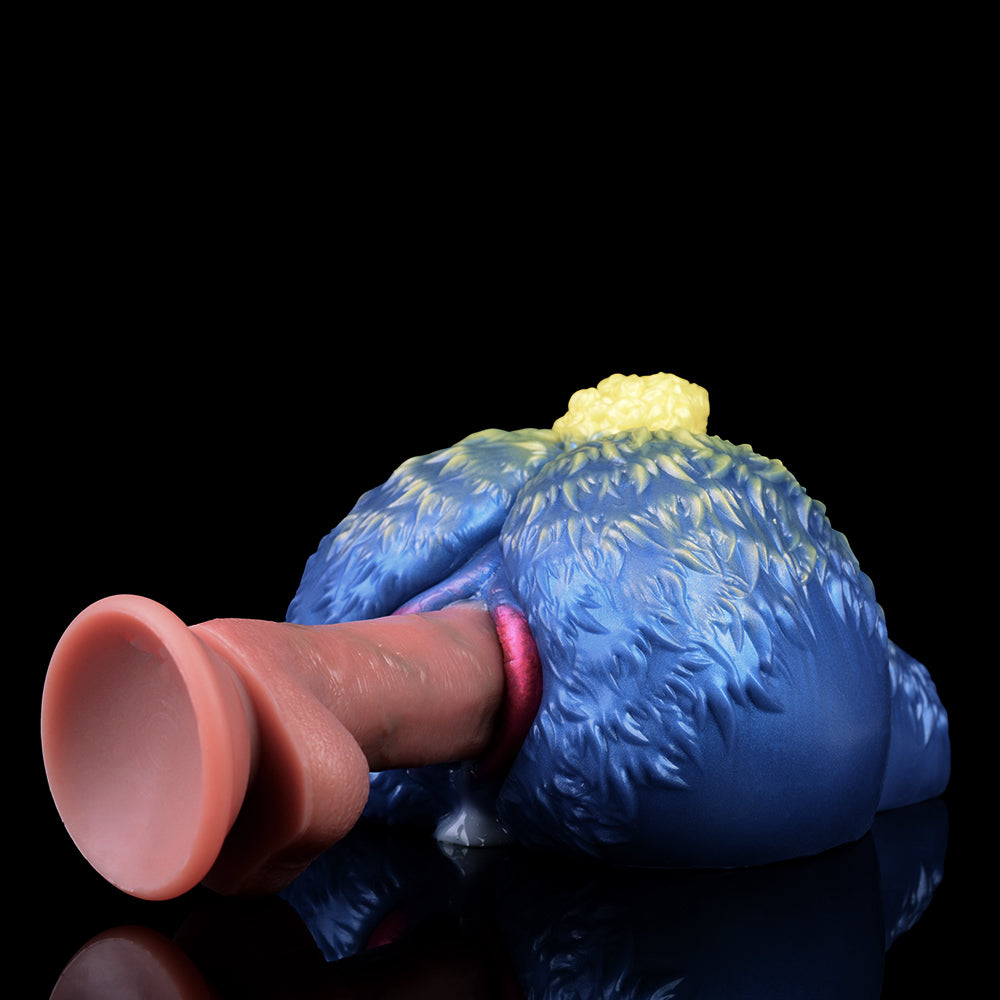 Blue sheep-shaped fantasy toy with yellow wool tuft and pink-tinted opening, front close-up