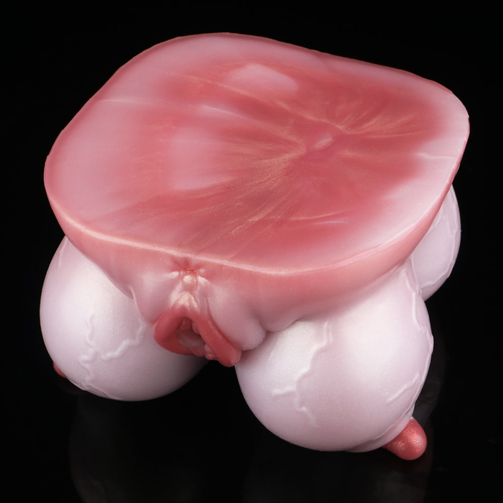Pink silicone anatomical toy with red-tinted opening and rounded base