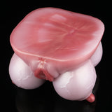Pink silicone anatomical toy with red-tinted opening and rounded base
