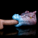 Blue-violet dragon fantasy sex toy held by hand, one side opening and eye visible