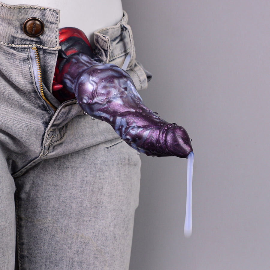 Purple monster squirting dildo dispensing from jeans pocket with clear tube and stream