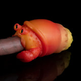 Orange squeeze toy crab face with wide red eyes and curled claws