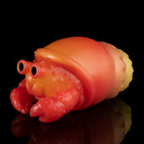 Orange squeeze toy crab with red claws and yellow tail, resting pose