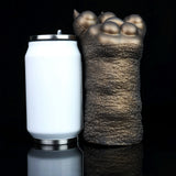 Bronze textured clawed hand standing next to a white can with silver base