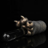 Bronze-colored textured hand figurine gripping a clear glass bottle