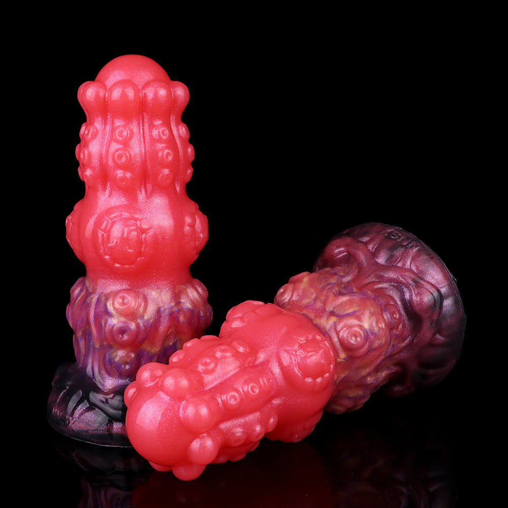 Fantasy-Anal-Dildo, seitliche Ansicht: roter Körper mit lila Relief und konkavem Sockel