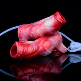 Red/pink silicone cock sleeve with wavy texture and blue tubing, angled view