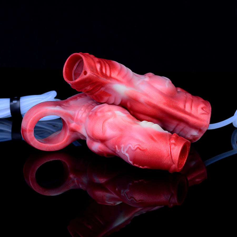 Red silicone cock sheaths with open tips, shown at an angle with connected tubing
