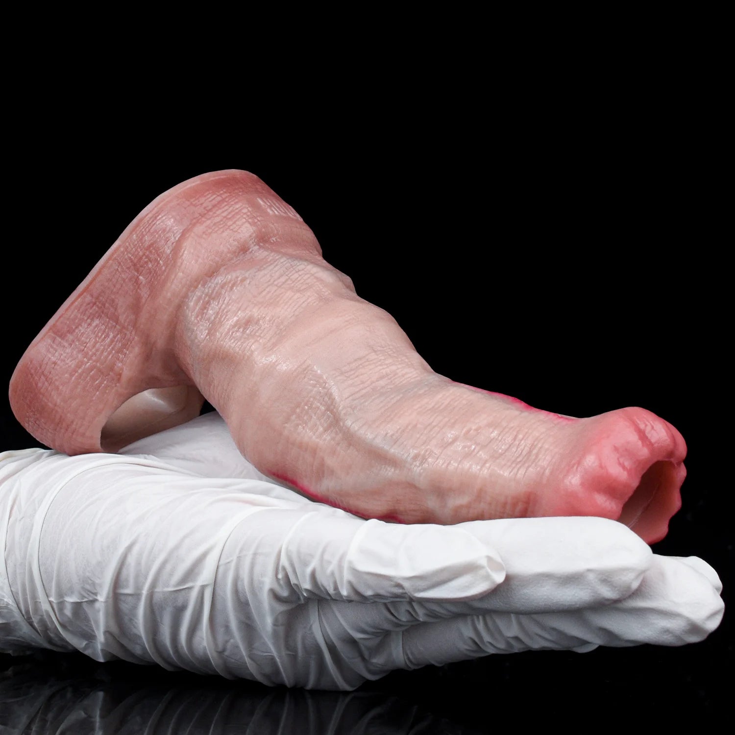 Pink horse cock sleeve resting on a folded white cloth, closed-tip end visible