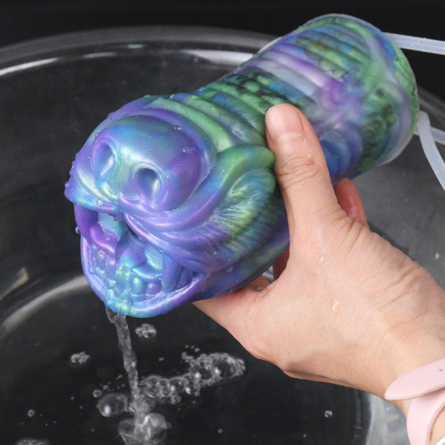 Iridescent wolf muzzle masturbator held by a bare hand, blue-green-purple finish