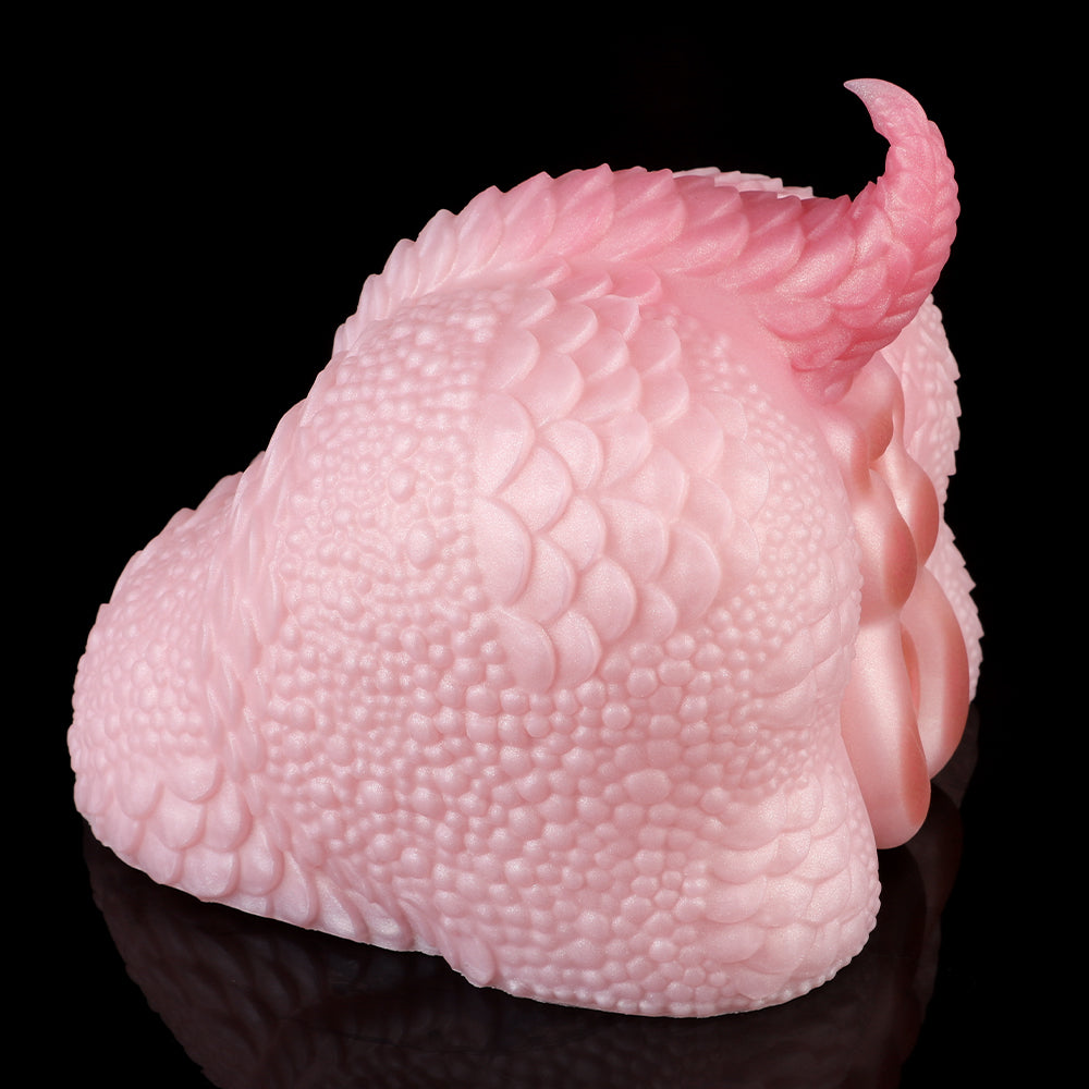 Pink dragon-shaped dual-ended toy close side view with textured scale pattern