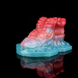 Side view of octopus-shaped insert on teal base with translucent red tentacle