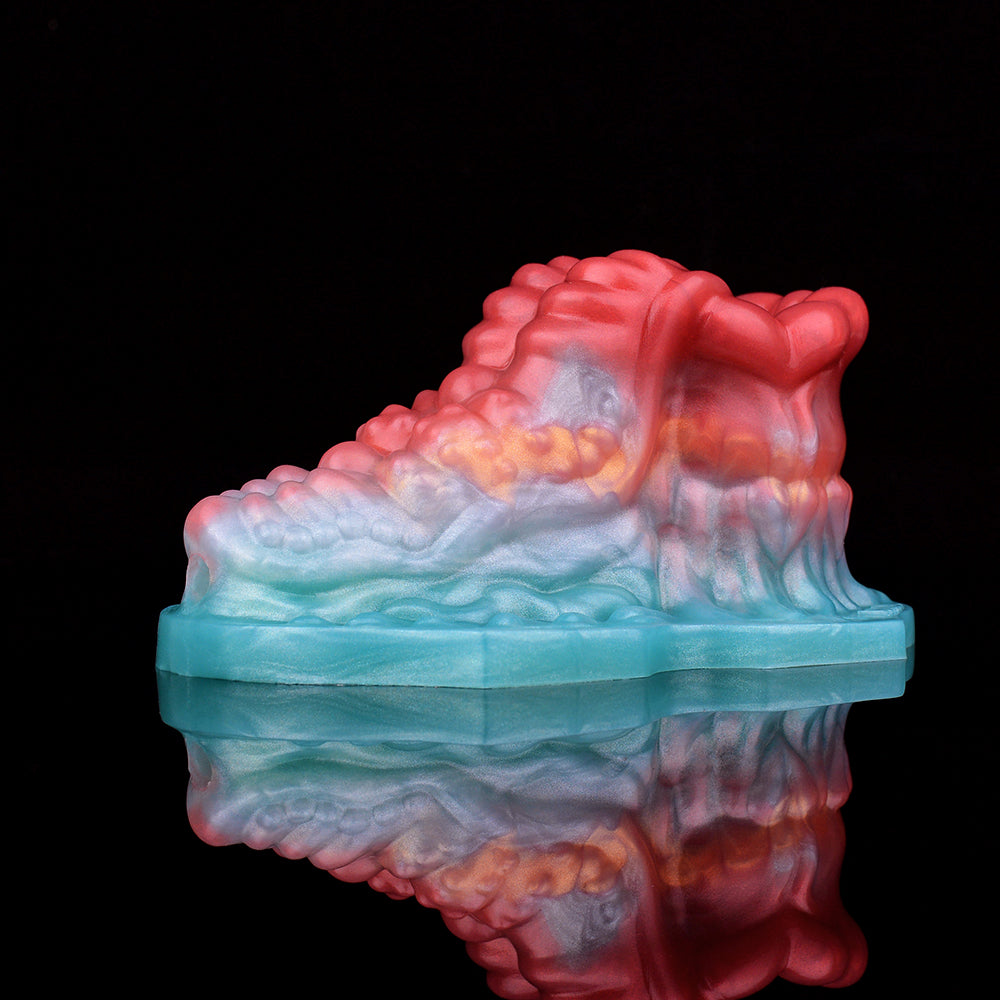 Front-on view of octopus-shaped insert on teal platform, red tentacles