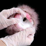 Gloved hands holding plush furry sleeve masturbator with pink inner insert