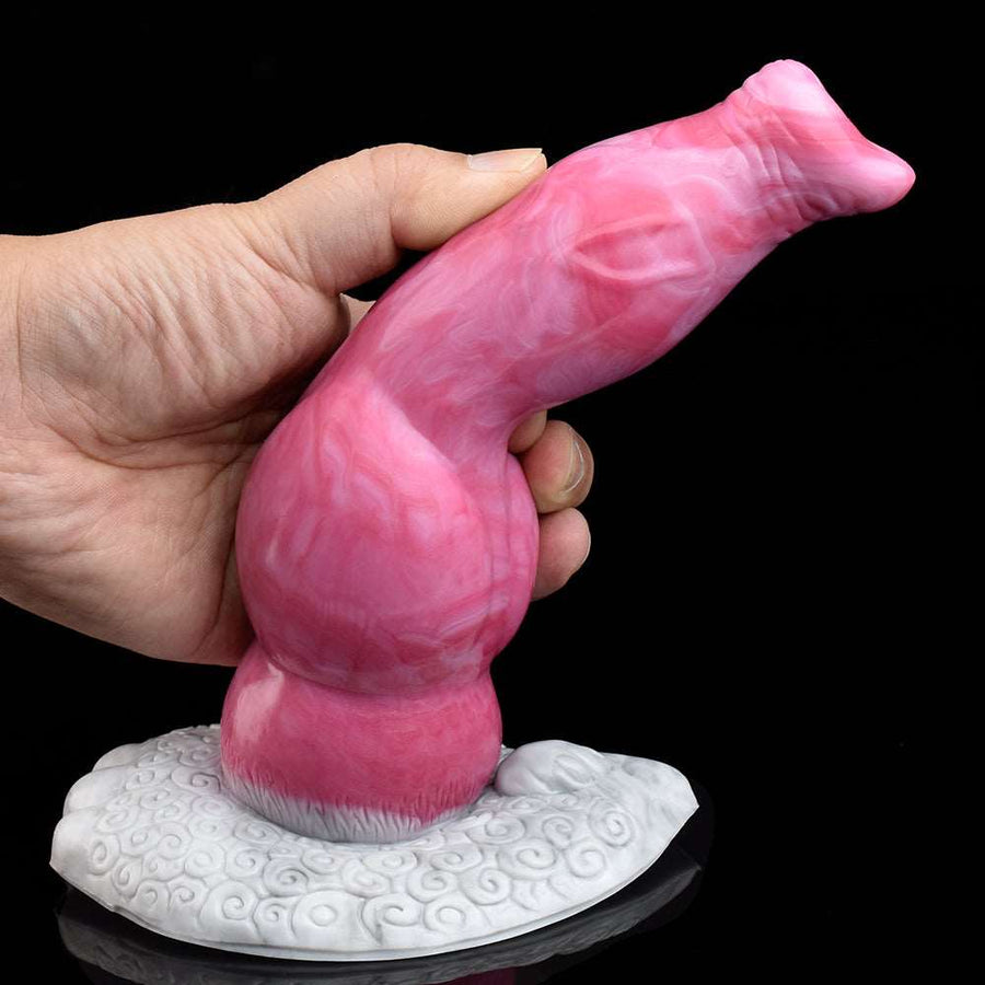Vibrating dog-shaped silicone vibrator, pink body, hand holding above textured white base