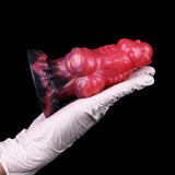 Side view of wolf butt plug: glossy pink body with ribbed details and dark tail