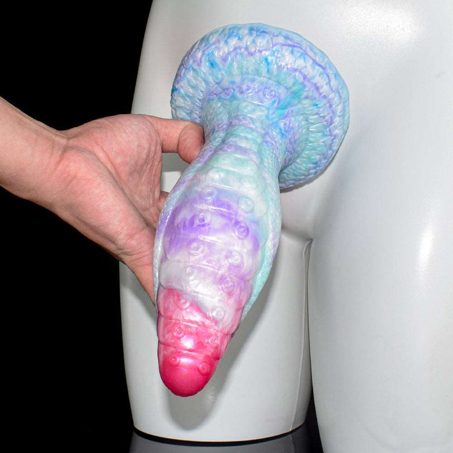 Iridescent octopus butt plug, held near head, pink-red tip, curved base, textured