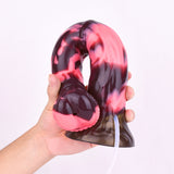 Minotaur dildo close-up: open nozzle end, black-and-red marbled body, white tube