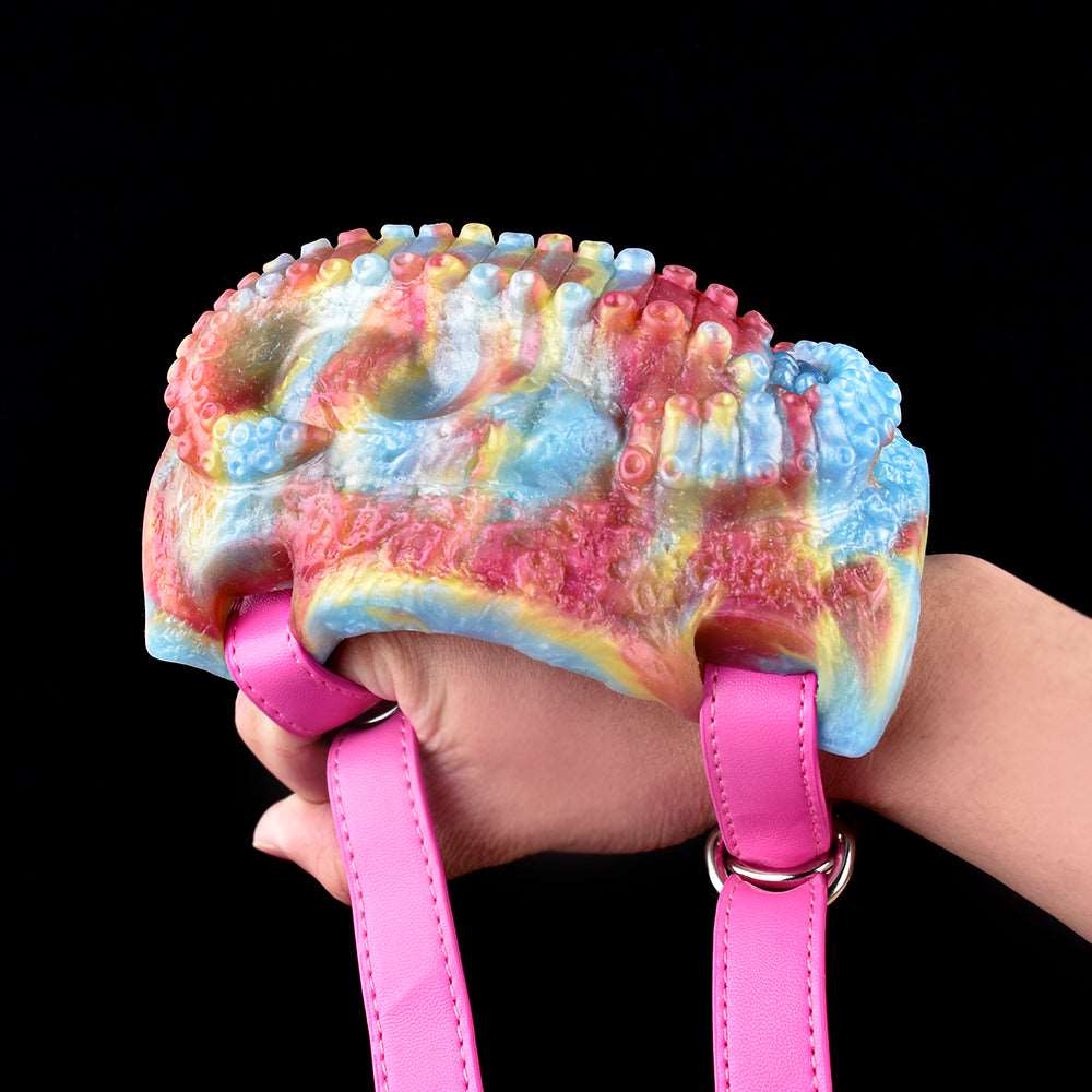 Colorful octopus-textured vibrator grinder held with pink wrist straps