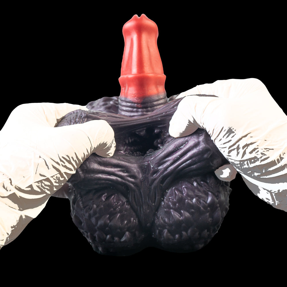 Purple textured hand-shaped toy with red horn top, held by white-gloved hands.