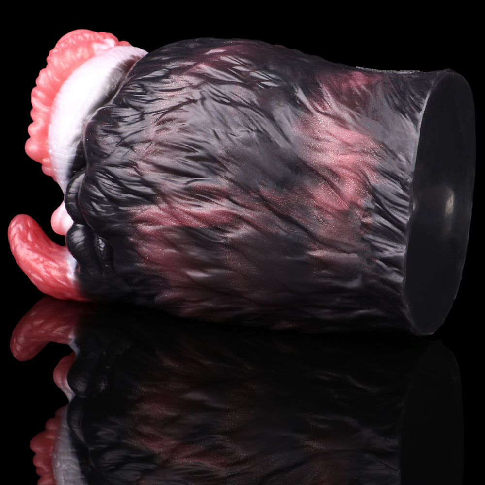 Side view creature toy with textured black fur and a pink ribbed opening