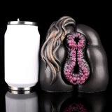 Hahama Mare Fleshlight mit violetten Noppen-Einsätzen und dekorativer Schlangenform, daneben Fläschchen