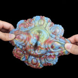 Side view octopus grinder sex toy held in hand, detailed tentacle ridges