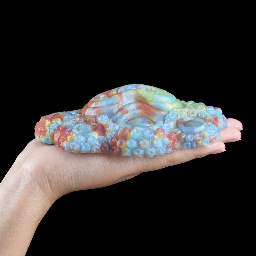 Long side profile of octopus-shaped grinder sex toy, iridescent blue and pink