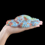 Long side profile of octopus-shaped grinder sex toy, iridescent blue and pink