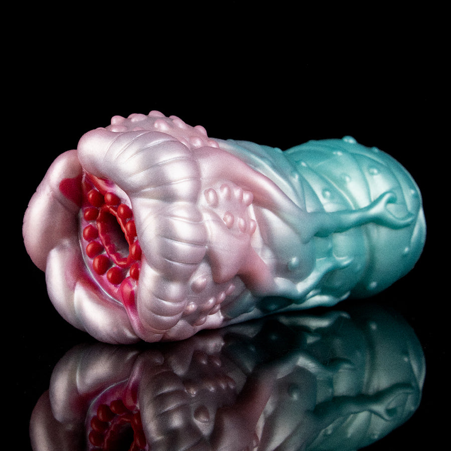 Alien-themed fleshlight-style stroker with pink and teal outer sections and red inner